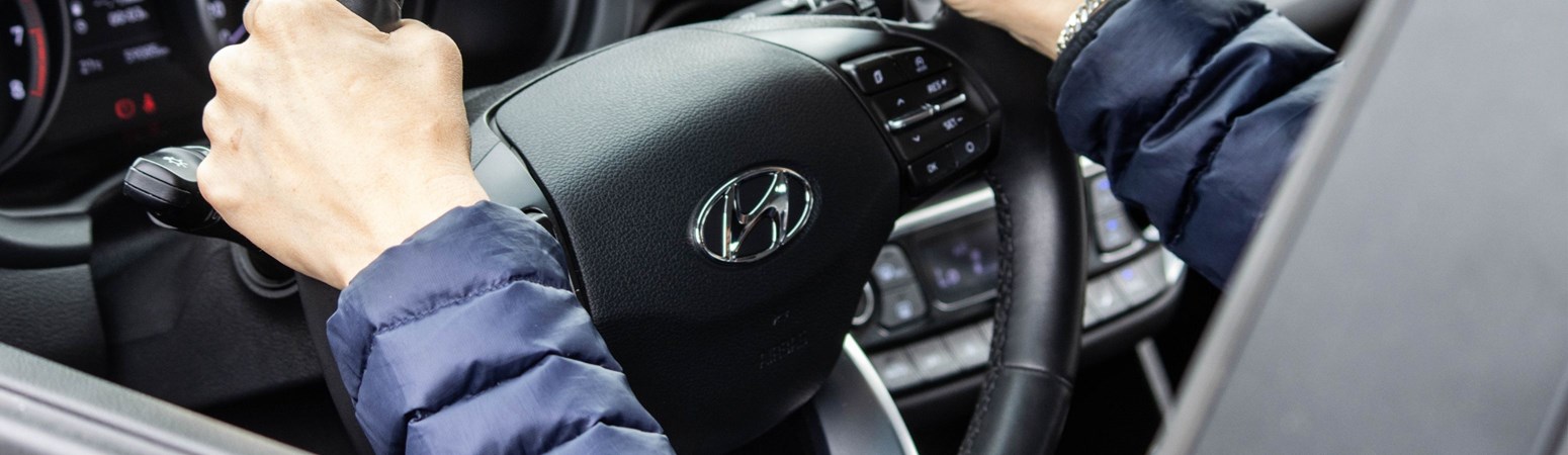Hyundai-ejer med hænderne på rattet i sin Hyundai
